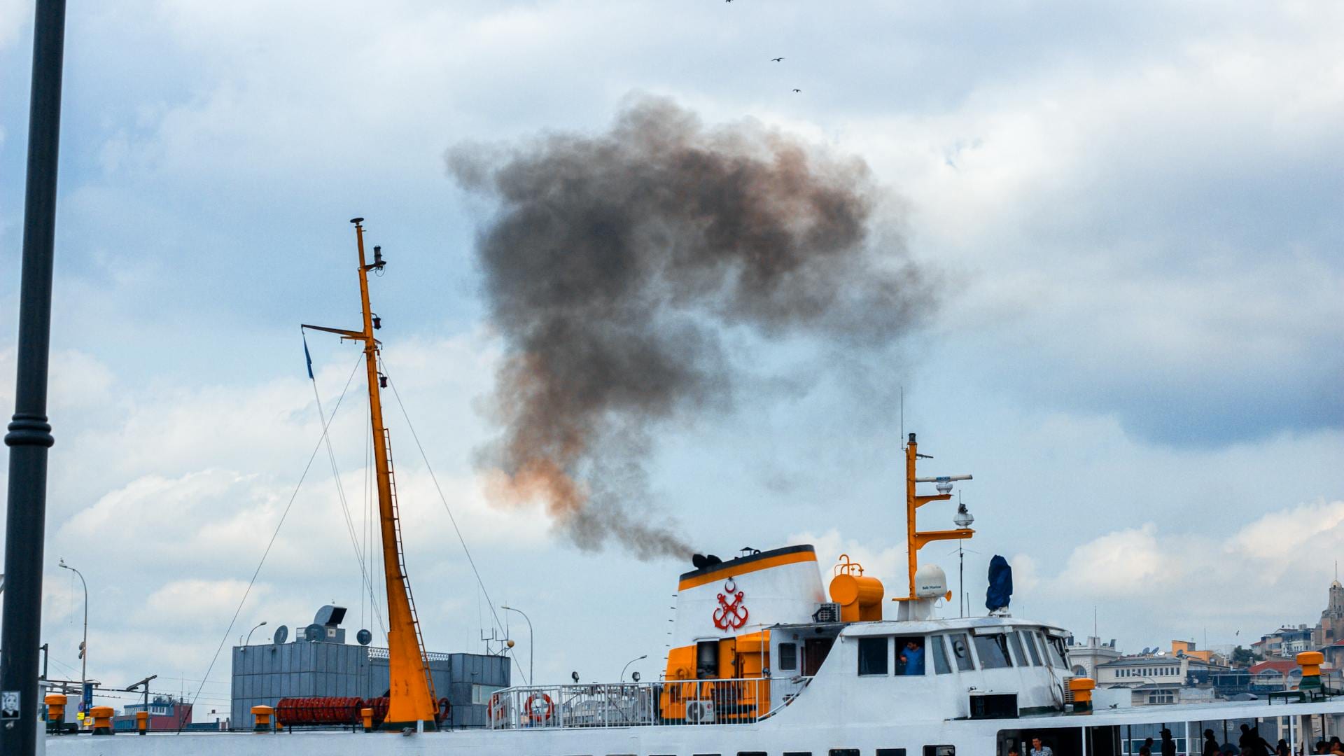 Passenger ferry exhaust stack emitting smoke from an EGCS scrubber